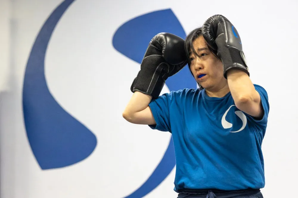 Woman practicing boxing defense at a martial arts class for women