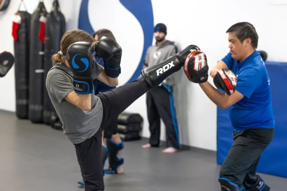 Adult student practicing kickboxing with another student at martial arts class in Rancho Bernardo