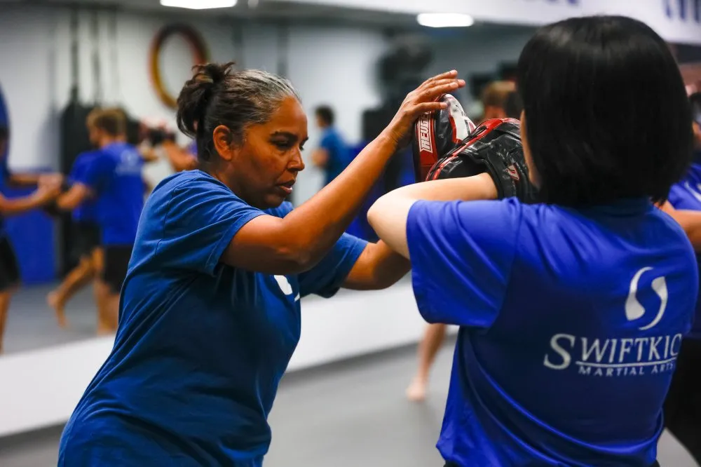 Women practicing catch wrestling techniques during martial arts training