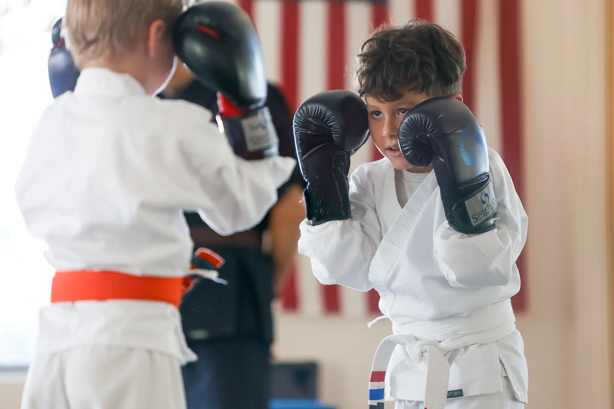 Children practicing martial arts techniques in kids martial arts class at SwiftKick San Diego