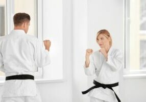man and woman sparring in black belt self defense