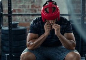 Boxer sitting beside the ring contemplating the effectiveness of martial arts for anxiety and depression.